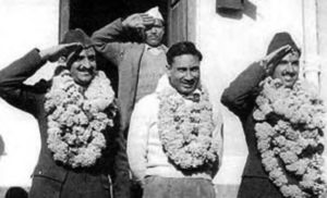 black and white photograph of several men wearing leis