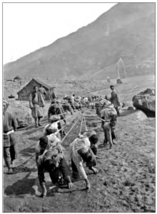 Image shows people pulling a houseboat upstream through the Yangtze rapids.