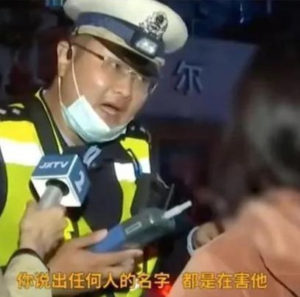 photograph of a chinese police officer speaking into a news reporter's microphone