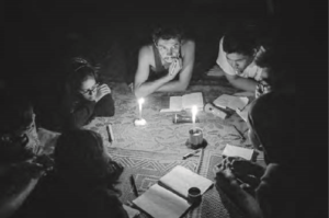 After a day’s trek near Kalaw, students and teacher write poems in a Pa-O home. They use candles as lights to see. 