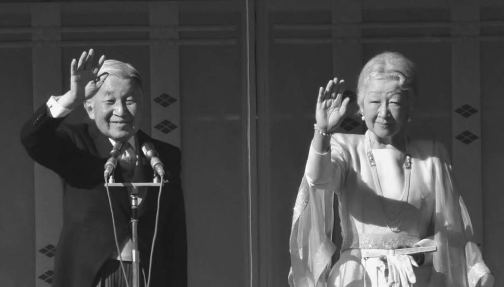 photo of an old man and woman smiling and waving at a crowd of people