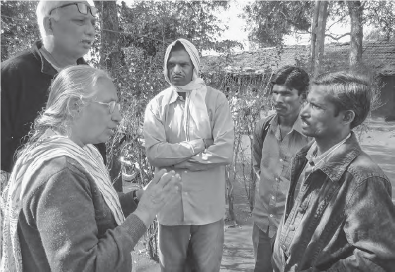 Picture of a woman and three men talking in a village