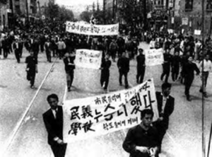 Photo of the 1960 Revolution in Korea. Protesters hold signs in the street. 