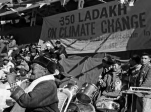 a crowd of protesters stand in front of a large banner that says 350 days on climate change.