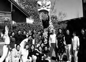 a group of people pose for a photo in front of a lion head