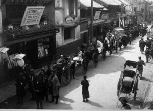 photo of a procession of men sitting on carriages