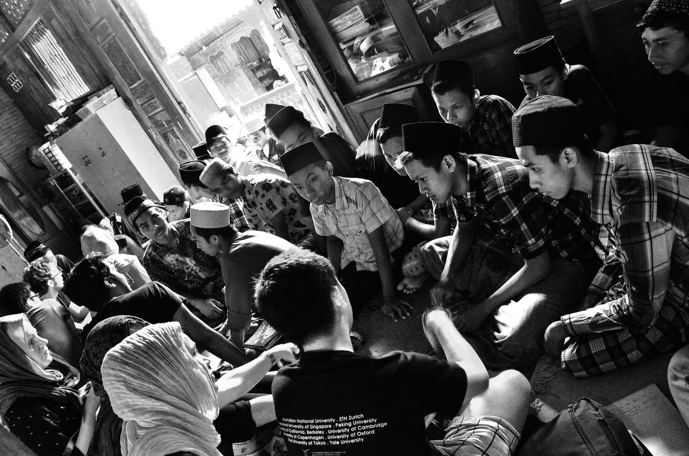 Students sit in a classroom, doing work. 