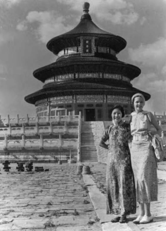 photo of two women posing for a photo in front of a temple