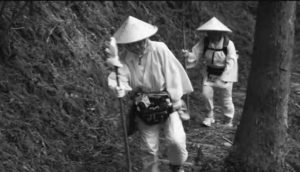 Image of two pilgrims walk a steep mountain path