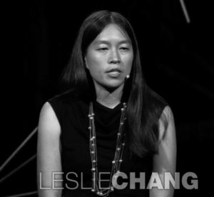 Photograph of Leslie Chang giving a speech. She is a young woman and is wearing a black top with a fashionable pearl necklace. 