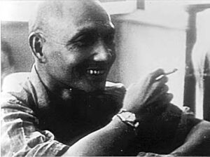 a man smiles while smoking a cigarette