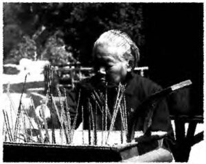 photograph of a woman burning incense