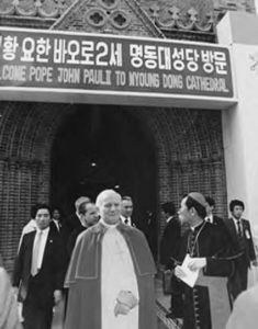 photo of a pope and several men in suits in front of a church