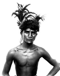 photo of a young boy wearing a feather headdress