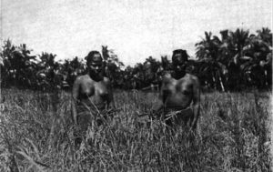 photo of two topless women standing and farming