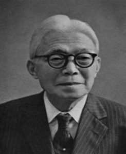 Photograph of Nambara Shigeru's face. He is an elderly man with white hair, circular glasses, and a Western style business suit. 