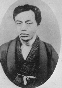 Photograph of Etō Shimpei as a young man from the waist up. He is wearing a traditional kimono and is staring intently at the photographer.