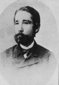 Portrait of Itagaki Taisuke's face. He is a middle-aged man with a black beard and is wearing a Western style business suit. He is looking beyond the photographer as if envisioning the future which is symbolizing his progressive thinking and his role as a visionary.