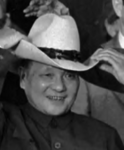 Deng Xiaoping wearing his Stetson hat while smiling. 