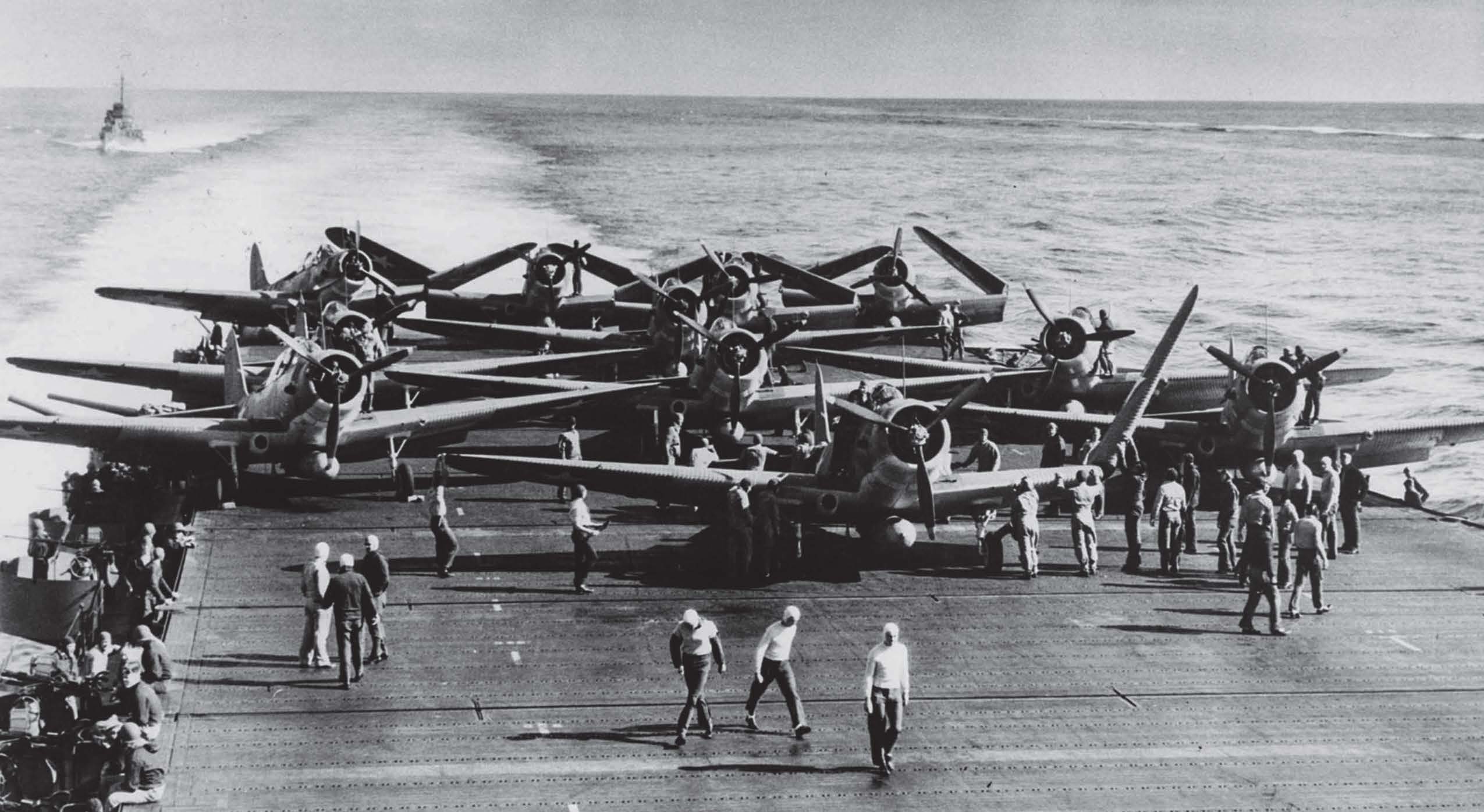 photo of several airplanes on the deck of a carrier