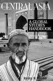 cover for Central Asia: A Global Studies Handbook. A man with a head covering stares into the camera. Behind him is a monument with a pointed archway.