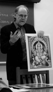 photo of a middle aged man holding art and speaking