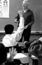 a student raises his hand while a teacher calls on him