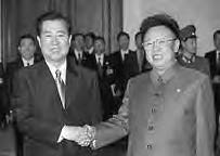 two men smile and shake hands