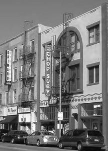 a photo of a street and buildings, with a chop suey sign