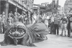 Image shows people are watching the Dalongdong Golden Lion in the street