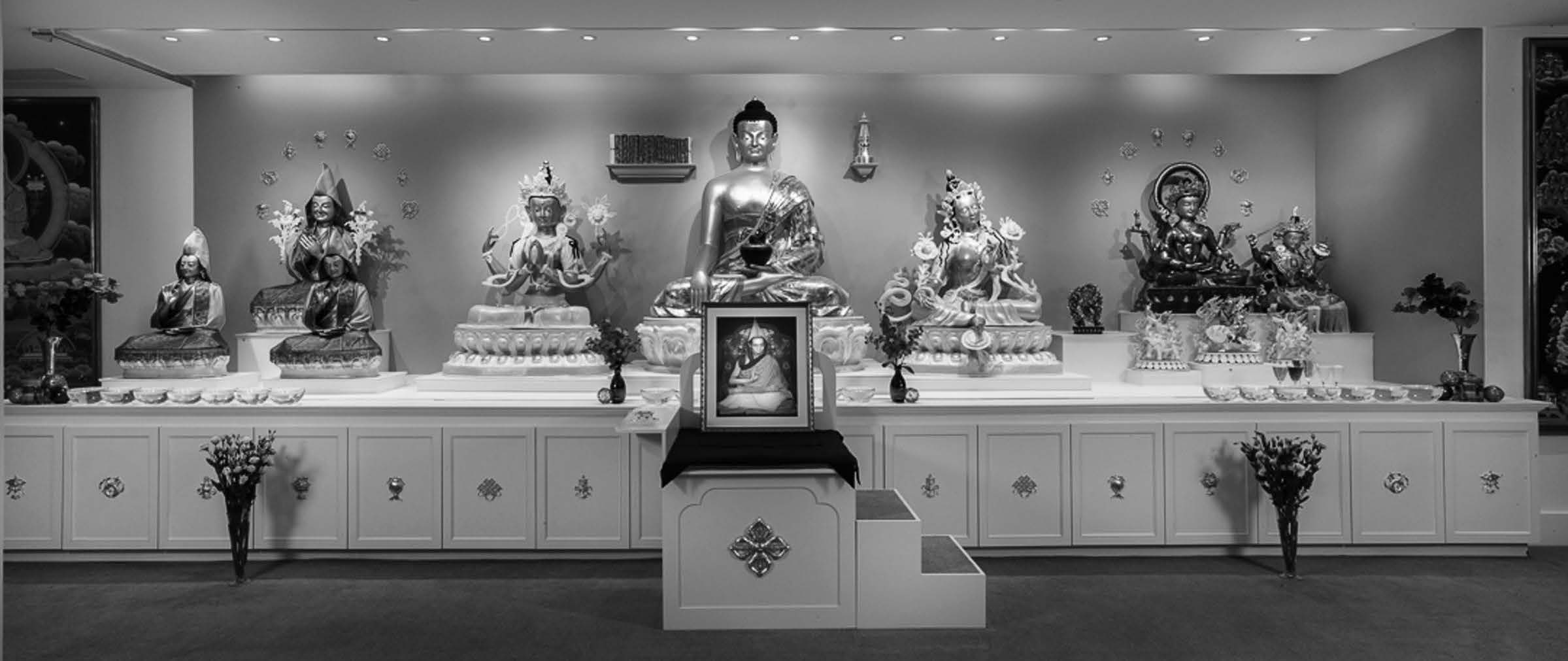 Shrine placed on a stage with many buddha statues  surrounding the stage. 