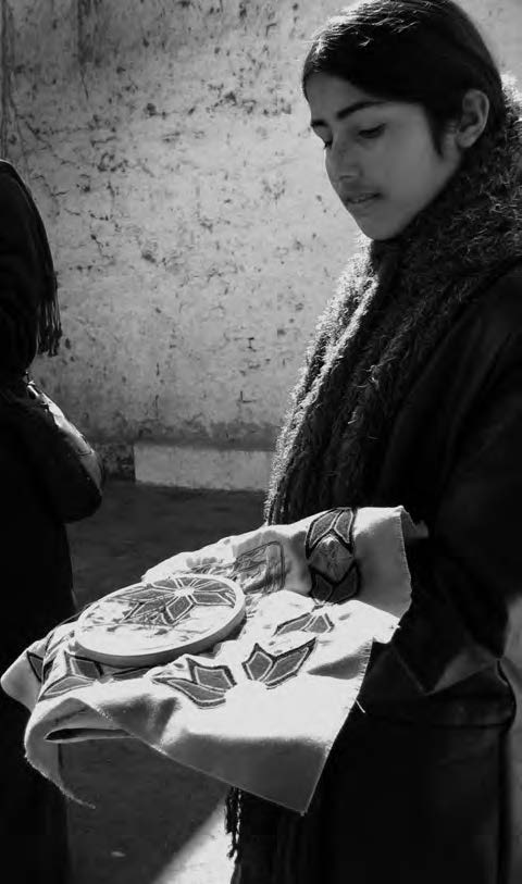 a girl shows her embroidery