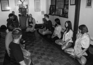 Students sitting and practicing meditation led by meditation master. 