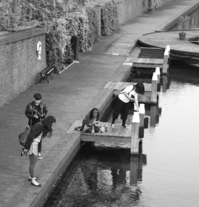 Students on a deck are conducting water testing on the river. 