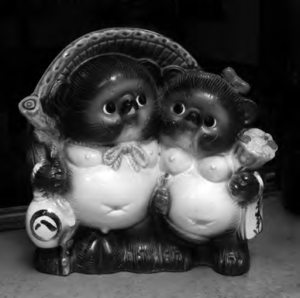 photo of a pair of tanuki statues wearing hats