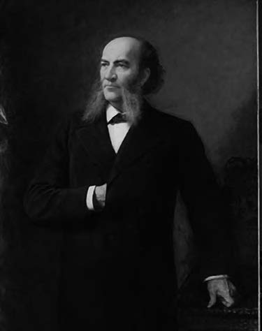 Man with a large greying beard in a victorian style waistcoat.