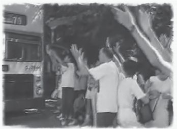 a group of people wave at a bus