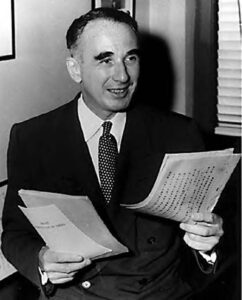 a man in a suit is holding papers and smiling away from the camera