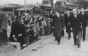 Picture of Emperor Hirohito greeting people standing on the street
