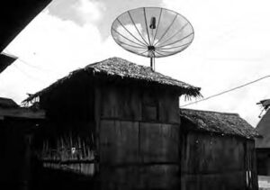 a thatch house with a satellite dish on top