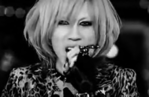 Screen capture from the LM.C “Hoshi no Arika” YouTube video. ©2011 Pony Canyon. In photo the woman is singing into a microphone. 