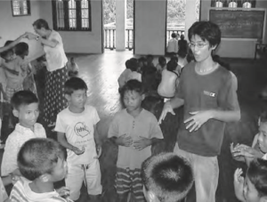 A student interacts with a group of adolescent orphans. 