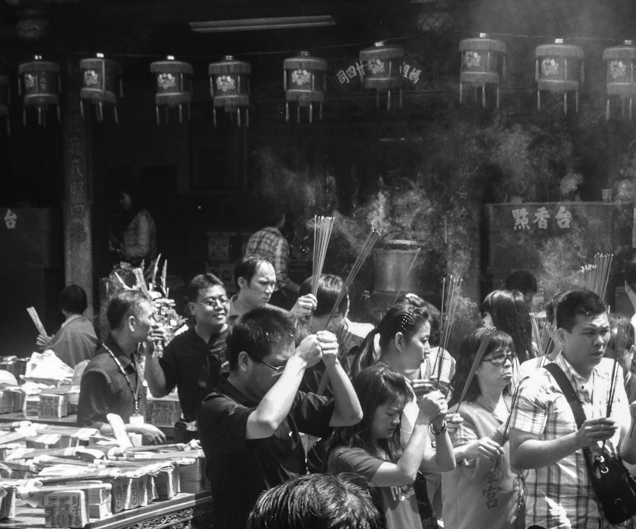 Worshippers amidst clouds of incense conduct a taoist bowing ritual. 