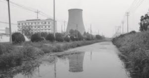 photo of a factory sitting along a river