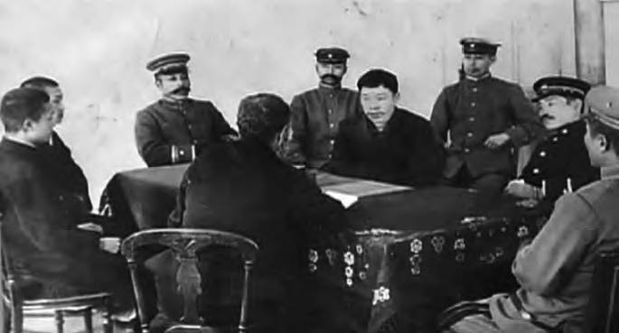 Interrogation of Chunggŭn. Police sit around Chunggŭn while he speaks. 