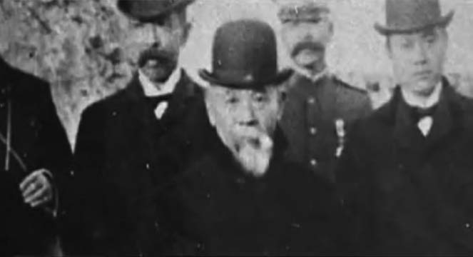 Photograph of Itō Hirobumi and his entourage. Itō Hirobumi is an old man with a large white beard and is wearing a bowler hat. 