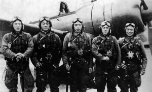 photo of five men in japanese air force uniforms in front of an airplane