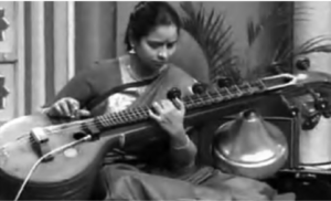photo of a woman in a sari playing a vina (looks like a guitar)