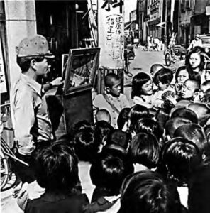 image of a man in front of many young children
