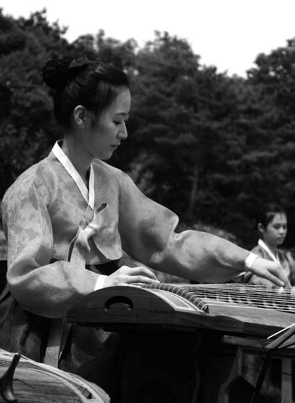 Korean musician playing on a gayageum.